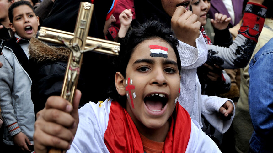 Egyptský koptský křesťanský chlapec křičí hesla, zatímco drží krucifix během protestu před budovou egyptské státní televize po sektářských střetech, Káhira, Egypt, 10. března 2011