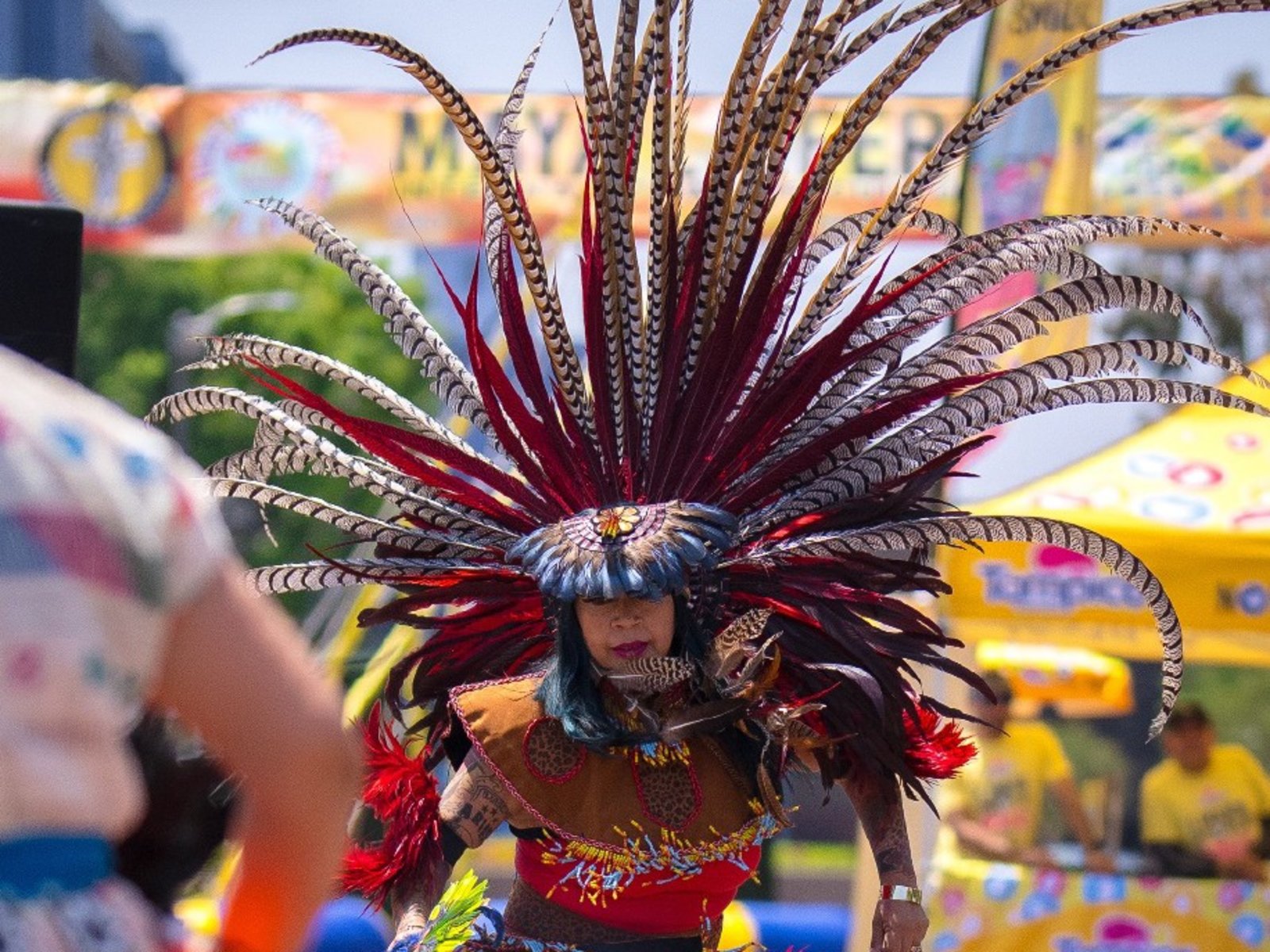 Tanečníci oblečení do opeřených čelenek oslavují mayskou kulturu